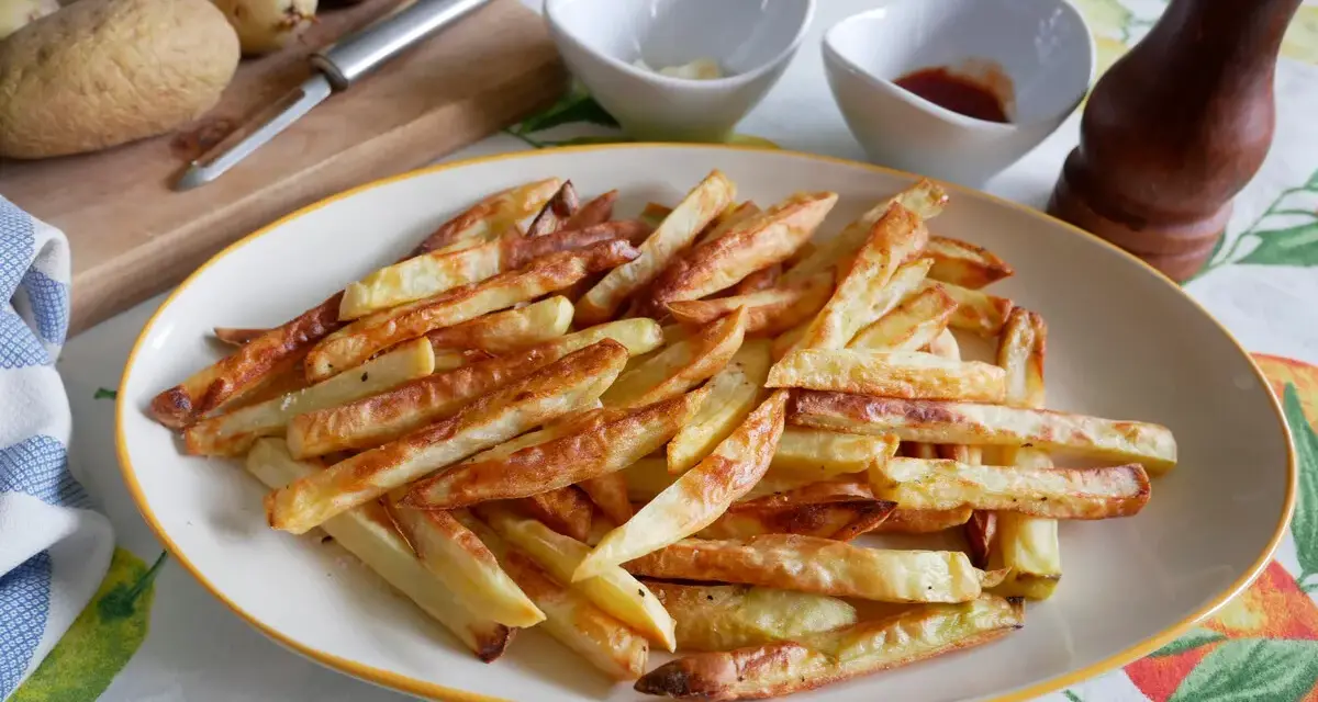 Patatas fritas doradas y crujientes, recién salidas de la freidora de aire. Perfectas para acompañar cualquier comida.