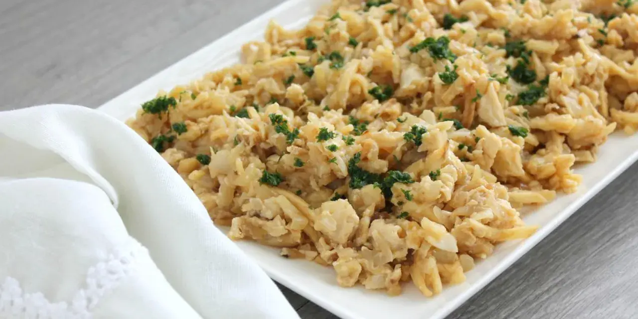 Delicioso plato de migas de bacalao desmenuzado, salteado y espolvoreado con perejil fresco.