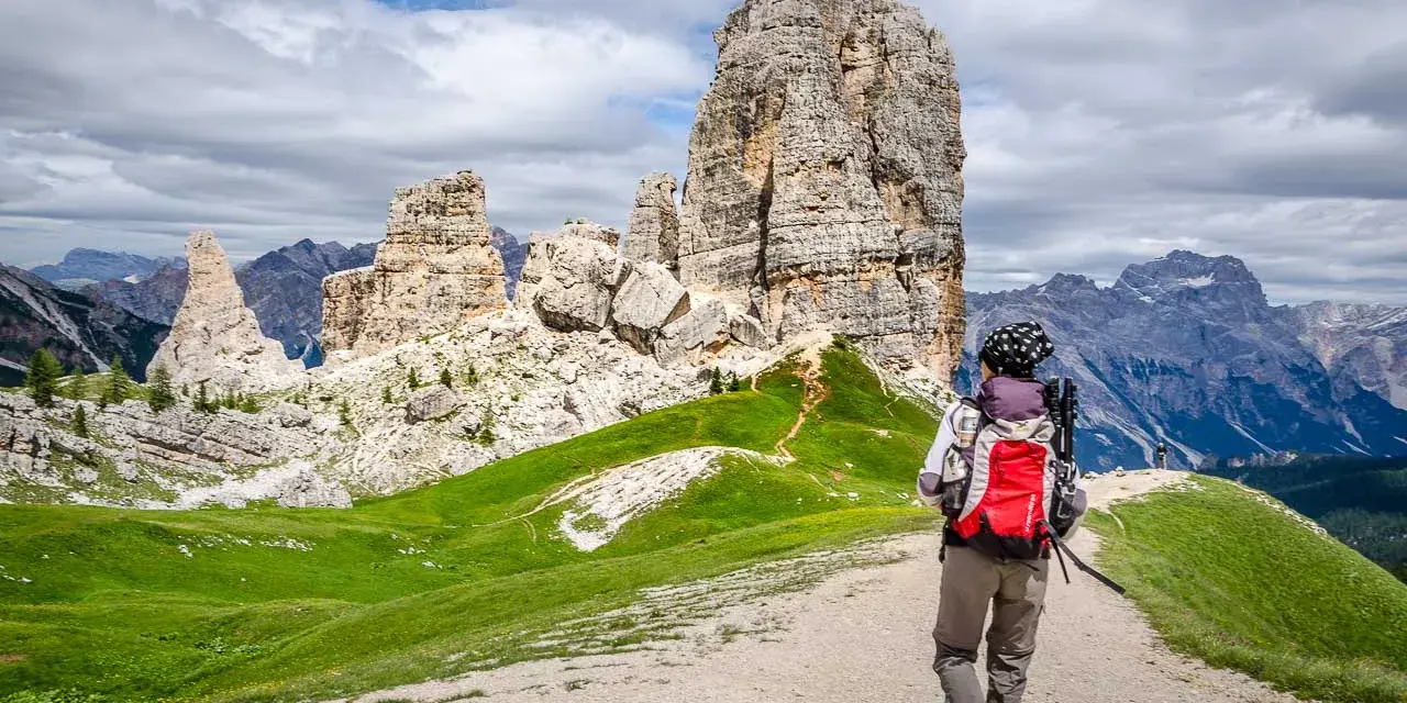 Wanderer auf einer **Cinque Torri Wanderung** mit Blick auf die markanten Felsformationen und die Dolomiten.