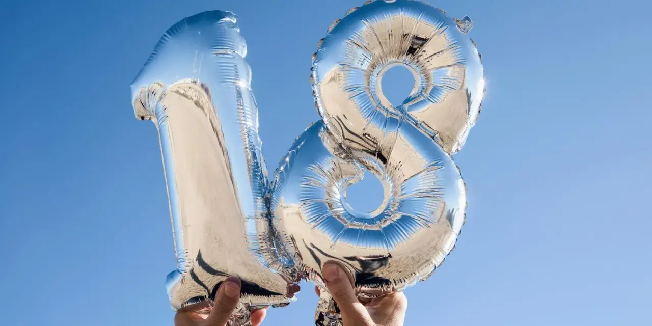 Silberne Folienballons in Form der Zahl 18 vor blauem Himmel.