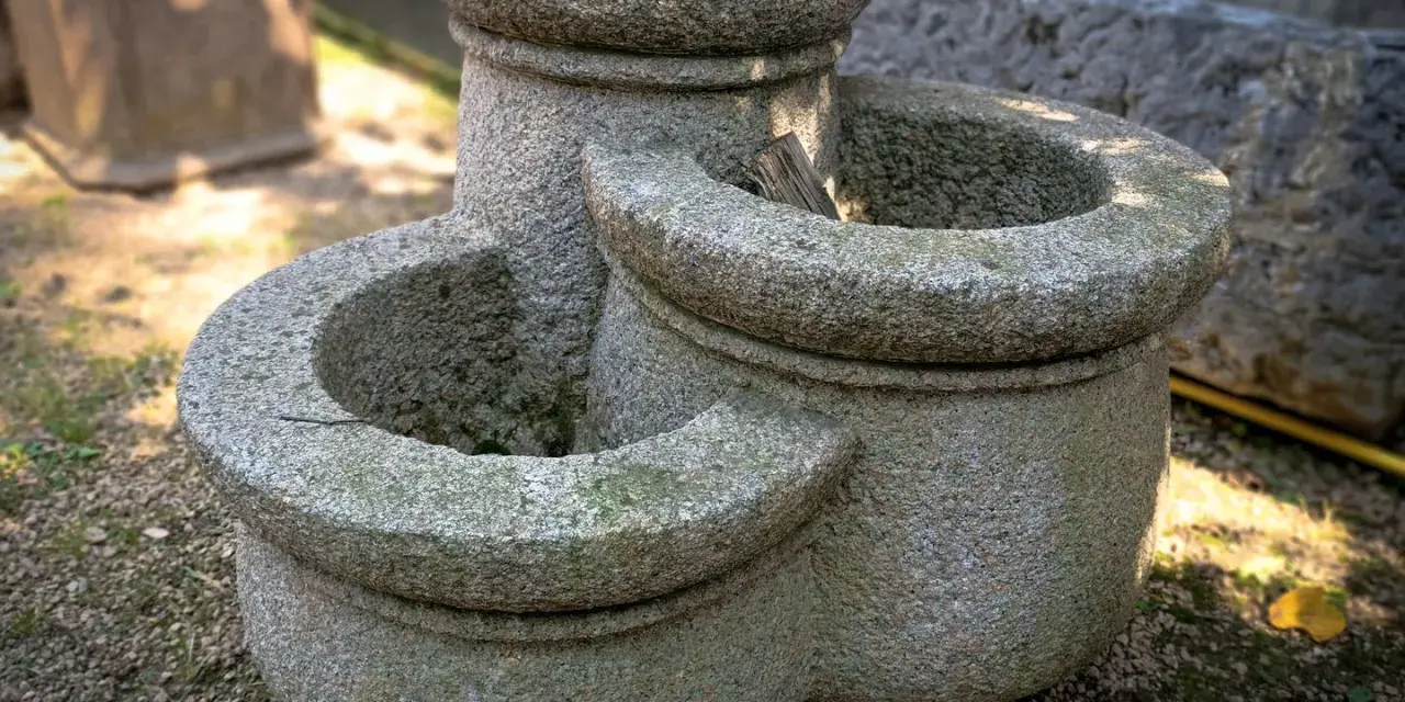 Tre anfore in pietra, perfette per idee giardino con anfore. Un elemento rustico e affascinante per il tuo spazio verde.