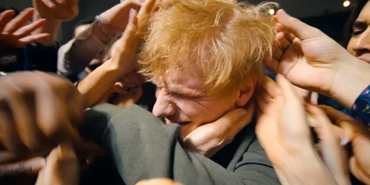 Ed Sheeran, mój azizam, otoczony przez tłum dłoni, które chcą go dotknąć.