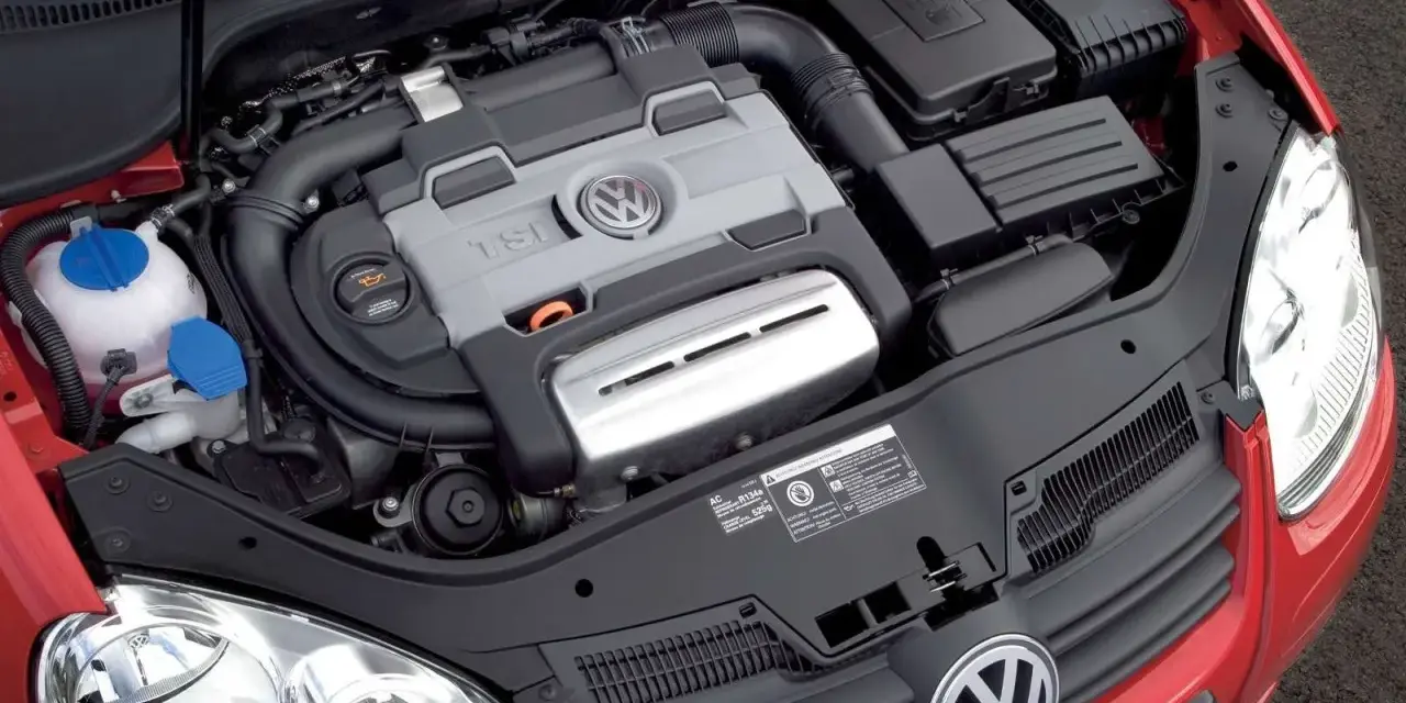 Silnik 1.4 TSI Twincharger w czerwonym Volkswagenie. Widoczne elementy układu dolotowego i chłodzenia.