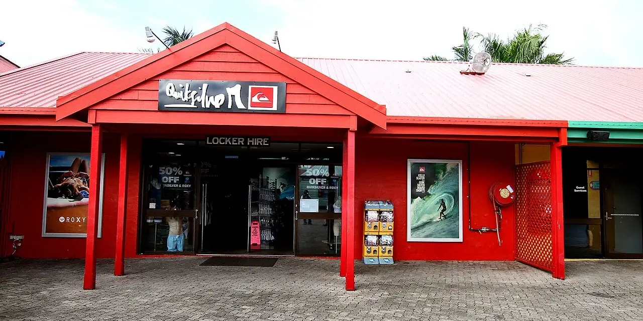 Sklep Quiksilver, znanej firmy odzieżowej dla surferów, z czerwonym logo i ofertą "Locker Hire".