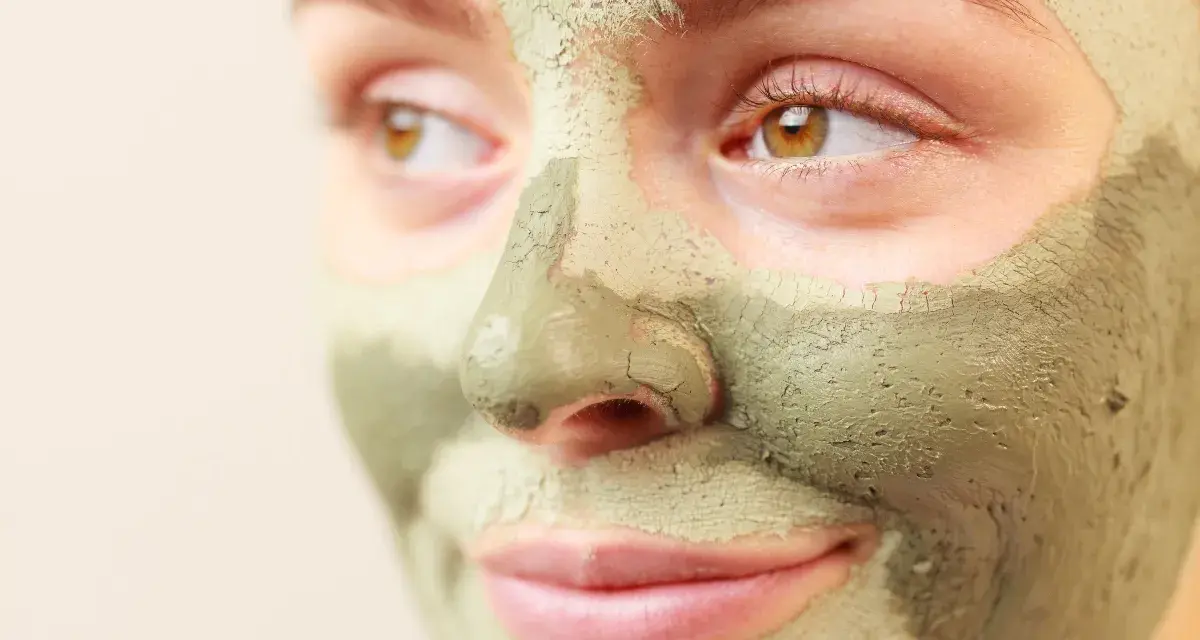 Primo piano di un viso con maschera all'argilla verde. Scopri a cosa serve l'argilla verde per la tua pelle.