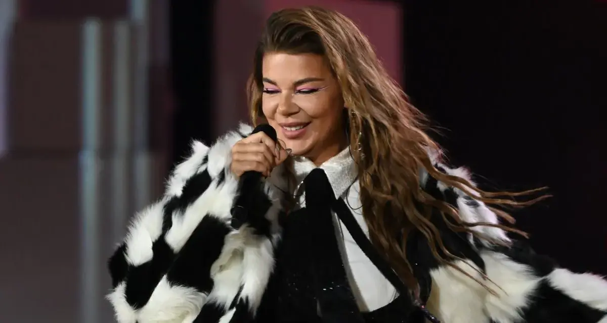 Edyta Górniak w szachownicznym futrze, z różowym makijażem oczu, śpiewa na scenie. Pamiętny występ na Eurowizji.