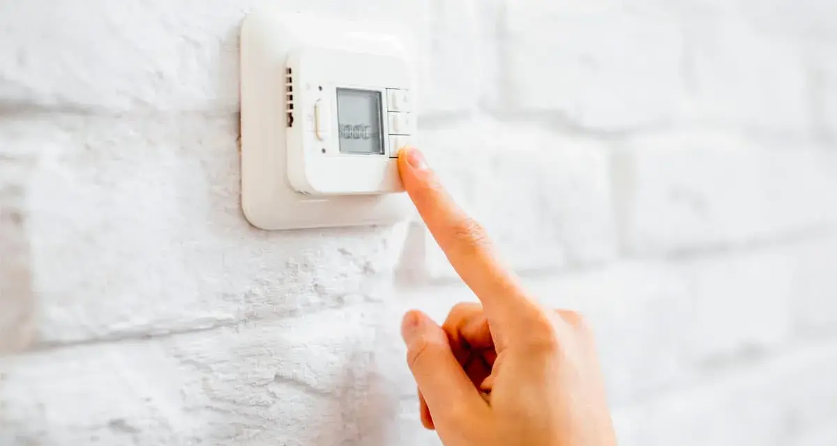 Ajustando el termostato para unos agradables grados calefaccion invierno.