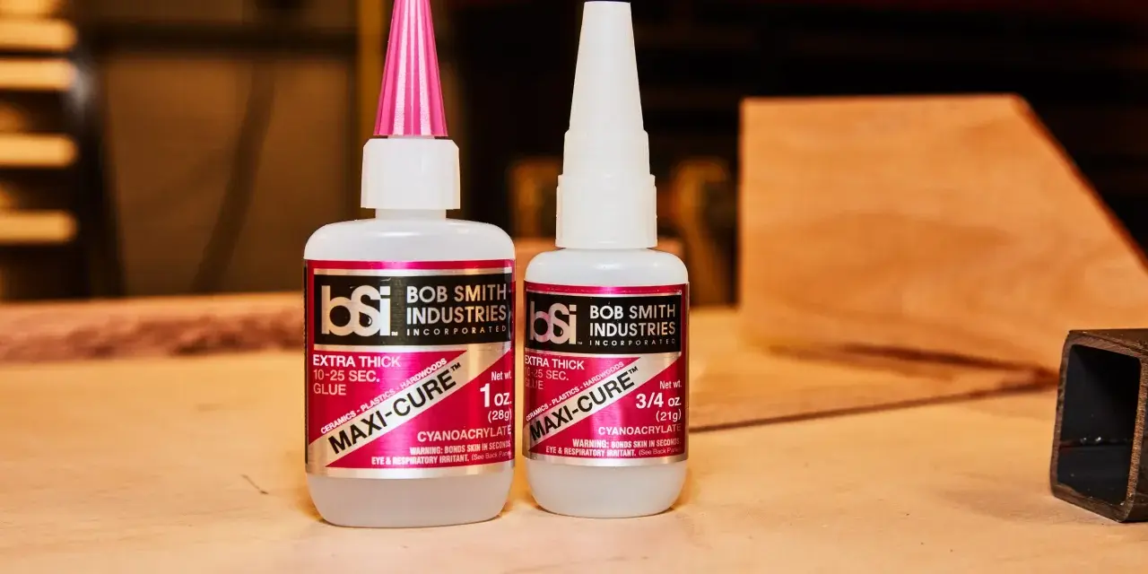 Two bottles of Bob Smith Industries Maxi-Cure glue, explaining why super glue is so strong due to its cyanoacrylate formula.