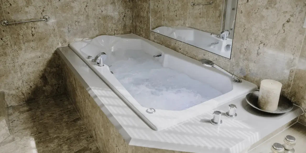 Baignoire balnéo avec jets d'eau bouillonnante, ambiance spa relaxante. Avis positif pour ce moment de détente.