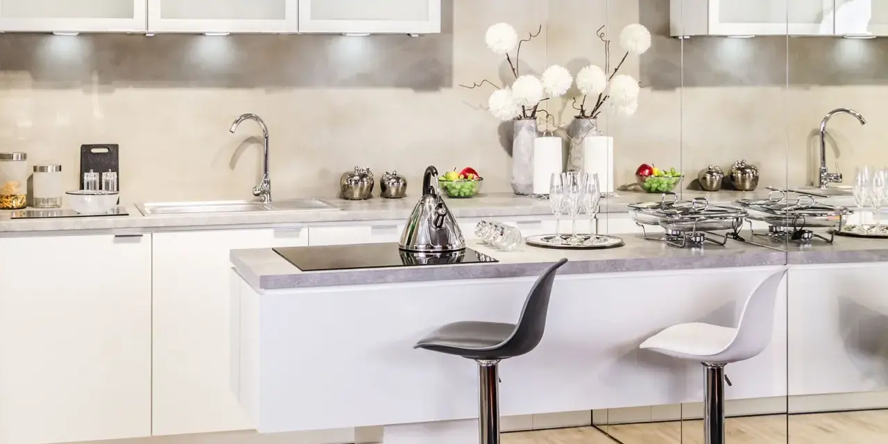 Nowoczesna kuchnia w stylu glamour: inspiracje dla eleganckiego wnętrza. Białe meble, chromowane dodatki i subtelne dekoracje tworzą luksusową atmosferę.