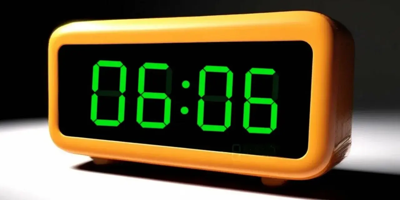 Pomarańczowy budzik cyfrowy pokazuje godzinę 06:06. Idealny czas na rozpoczęcie dnia lub na przerwę.