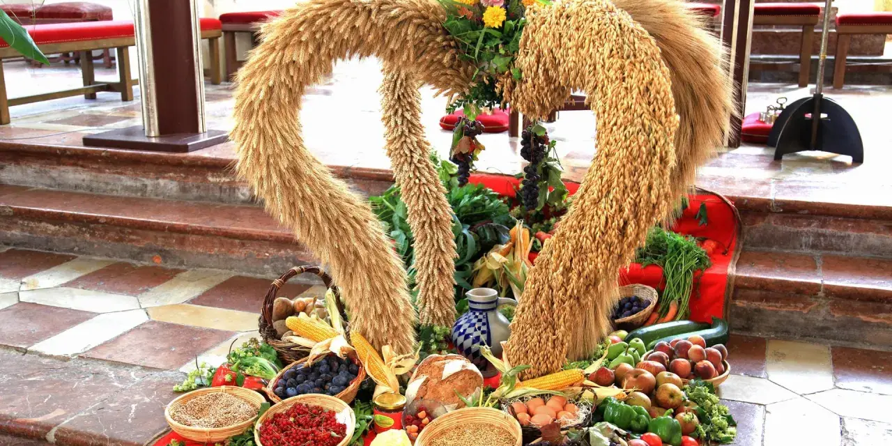 Erntedankfest: Herz aus Getreide mit Früchten, Gemüse und Brot.