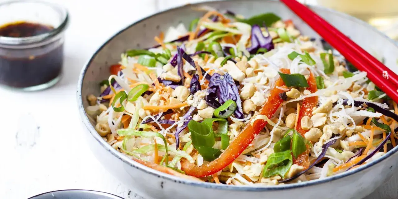 Bunter Sommerrollen Salat mit Reisnudeln, Rotkohl, Karotten, Paprika und Erdnüssen. Perfekt für heiße Tage!