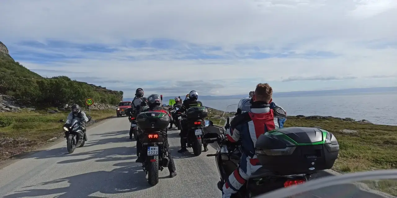 Motocykliści jadący w kierunku Nordkapp w Norwegii, podziwiając malownicze krajobrazy wybrzeża.