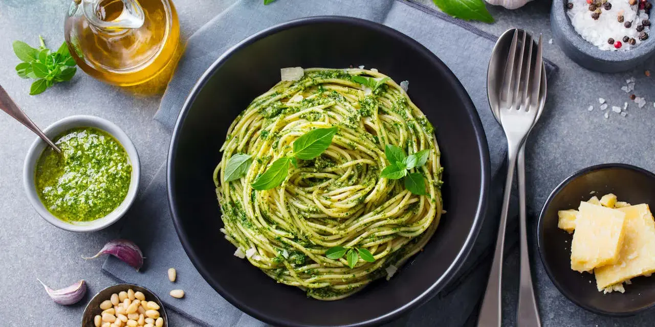 Pyszne spaghetti z pesto, idealne co na obiad zamiast mięsa. Podane z parmezanem, orzeszkami pinii i świeżą bazylią.