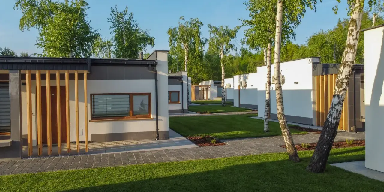 Nowoczesne domki na riviera camp otoczone zielenią i drzewami.