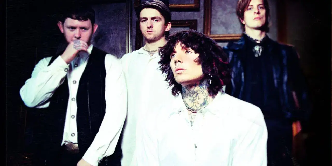 Les membres de Bring Me The Horizon posent ensemble, vêtus de blanc et de noir, dans une ambiance sombre et stylisée.