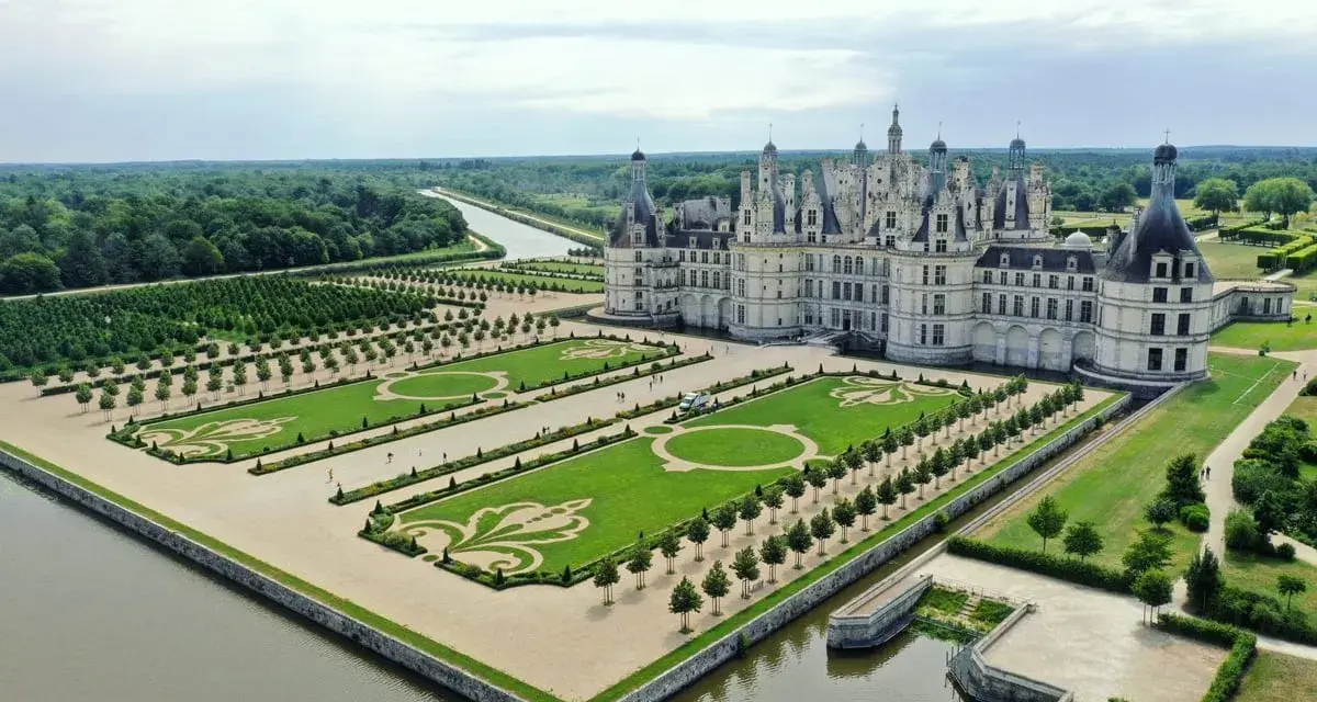 Le plus beau château de France, Chambord, se dresse majestueusement avec ses jardins à la française et un canal.
