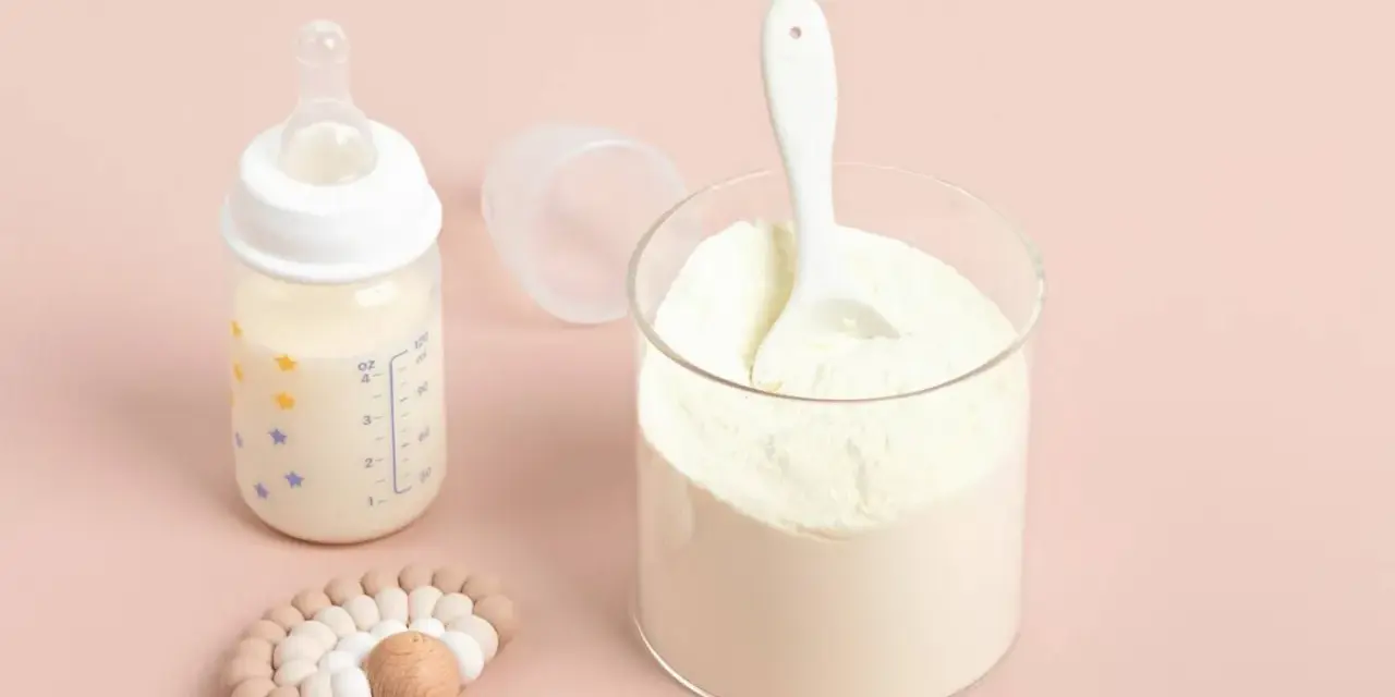Słoik z mlekiem w proszku i butelka z mlekiem. Pediatrzy często polecają odpowiednie mleko początkowe dla niemowląt.