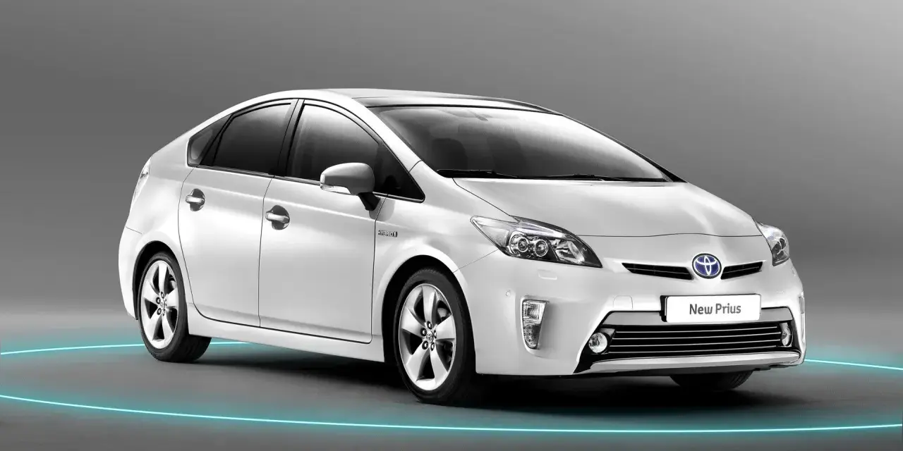 Biały Toyota Prius 3, z niebieską obwódką wokół, prezentuje się nowocześnie.