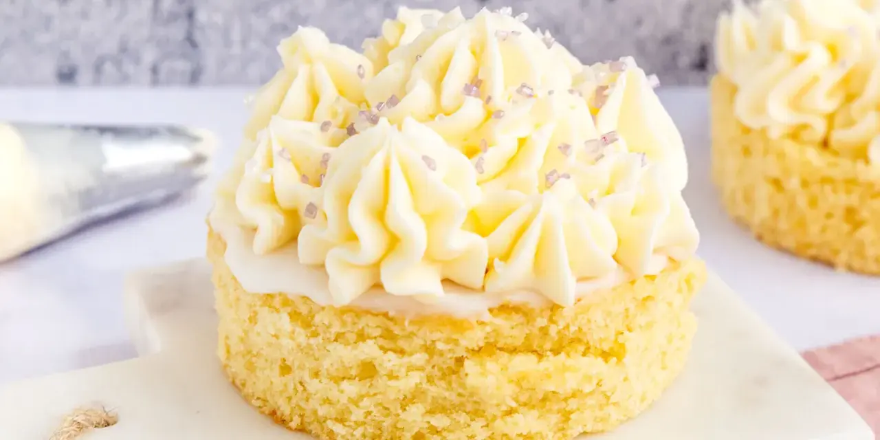 Kleiner Kuchen mit Buttercreme ohne Pudding, verziert mit lila Zuckerstreuseln.