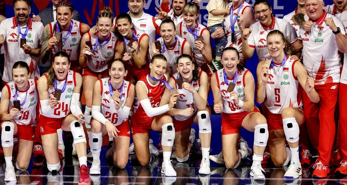 Drużyna siatkówki kobiet Polska świętuje sukces w Lidze Narodów. Zawodniczki z medalami na szyjach i uśmiechami na twarzach.