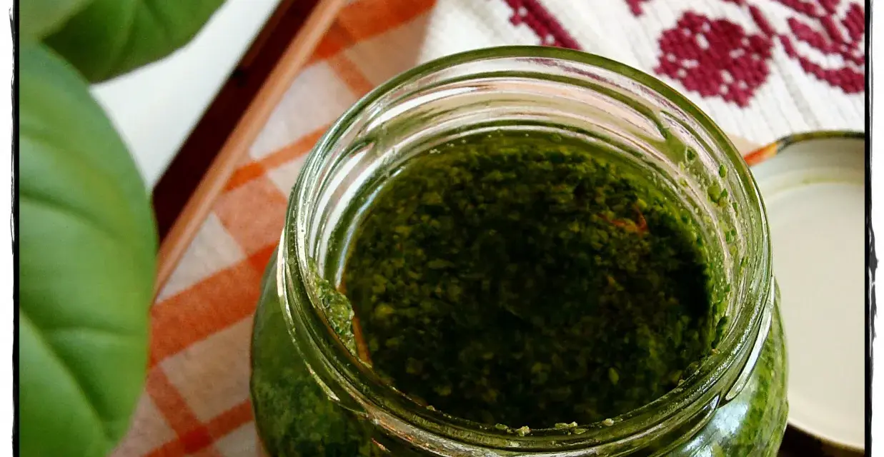 Słoik domowego pesto z bazylii, obok świeże liście. Idealne do makaronu!