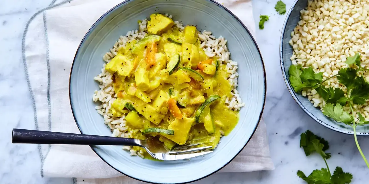 En skål med ris och en krämig currysås med grönsaker. Perfekt för ett snabbt currysås recept.