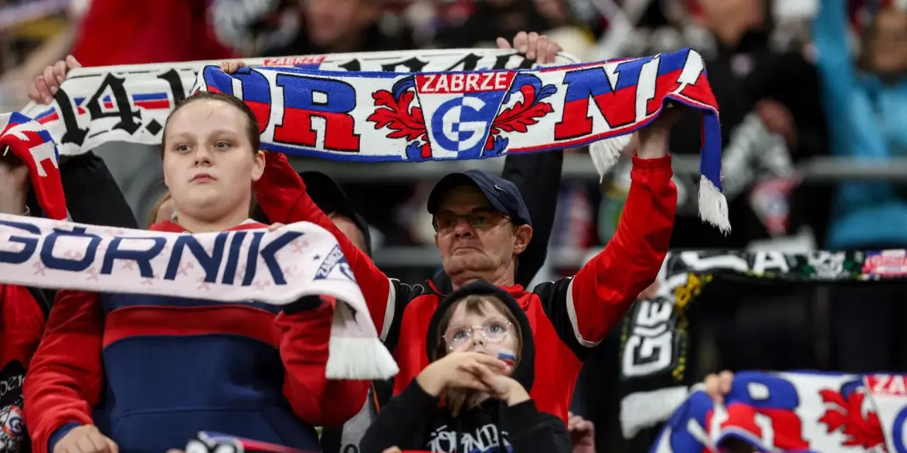 Kibice Górnika Zabrze na meczu z GKS Katowice. Widać szaliki z napisem "Górnik Zabrze" i herbem klubu.