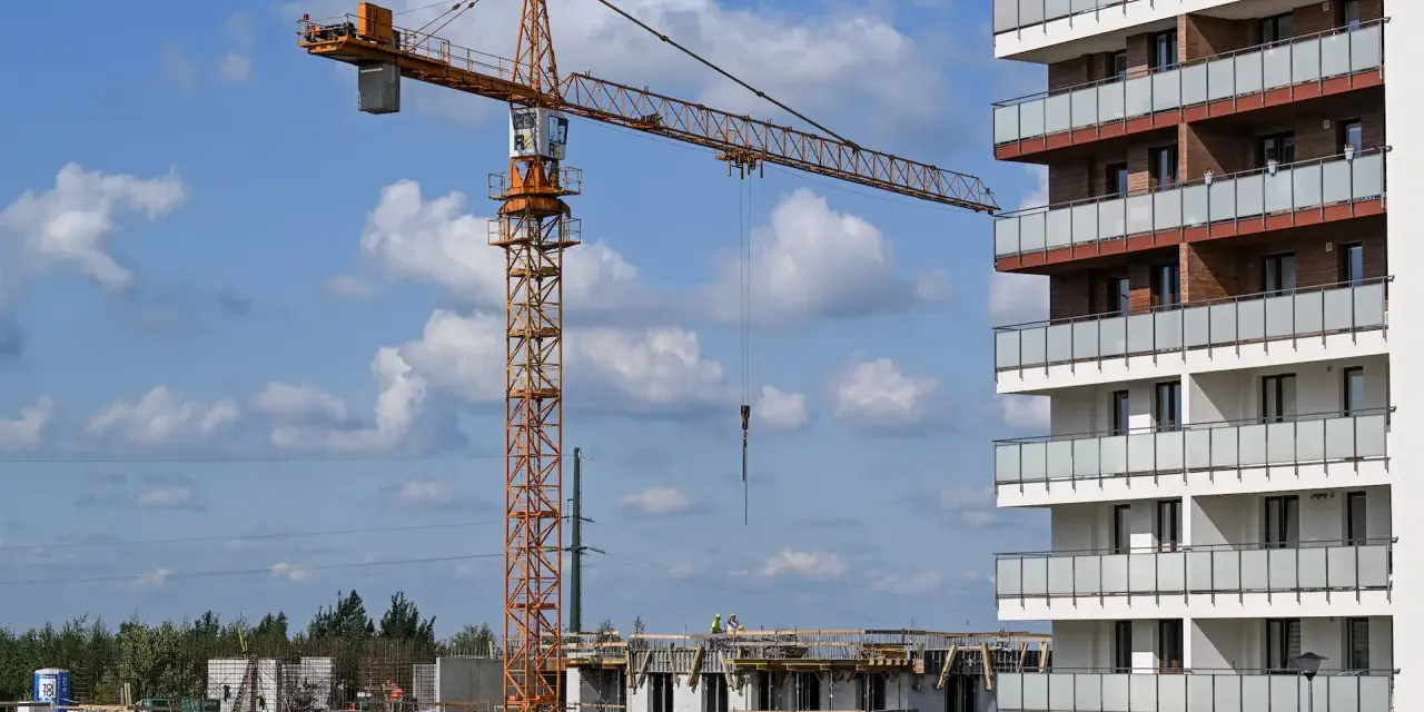 Budowa nowego osiedla przez lex deweloper. Żuraw budowlany pracuje przy nowoczesnym bloku mieszkalnym.