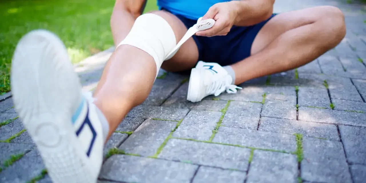 En löpare bandagerar sitt ben, möjligen för att lindra smärta från benhinneinflammation symptom.