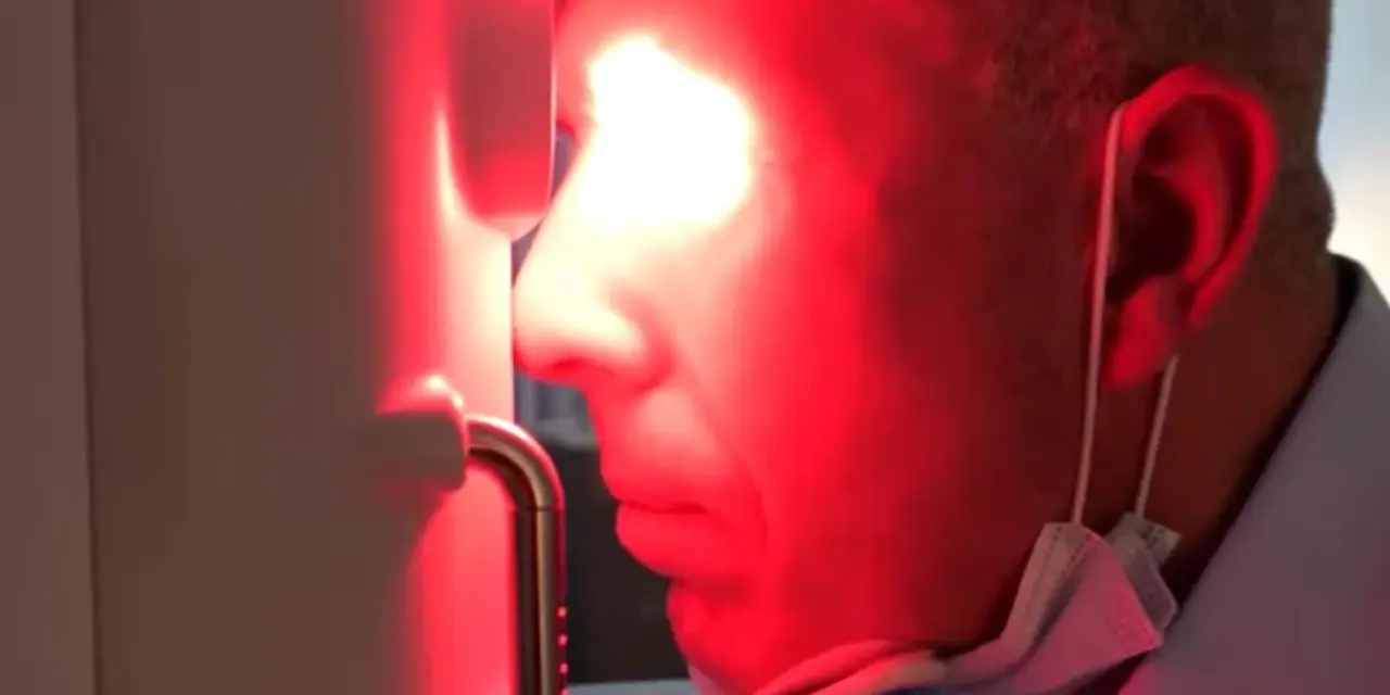Uomo con maschera chirurgica sotto il mento, riceve fotobiomodulazione facciale. Attenzione alle fotobiomodulazione controindicazioni.
