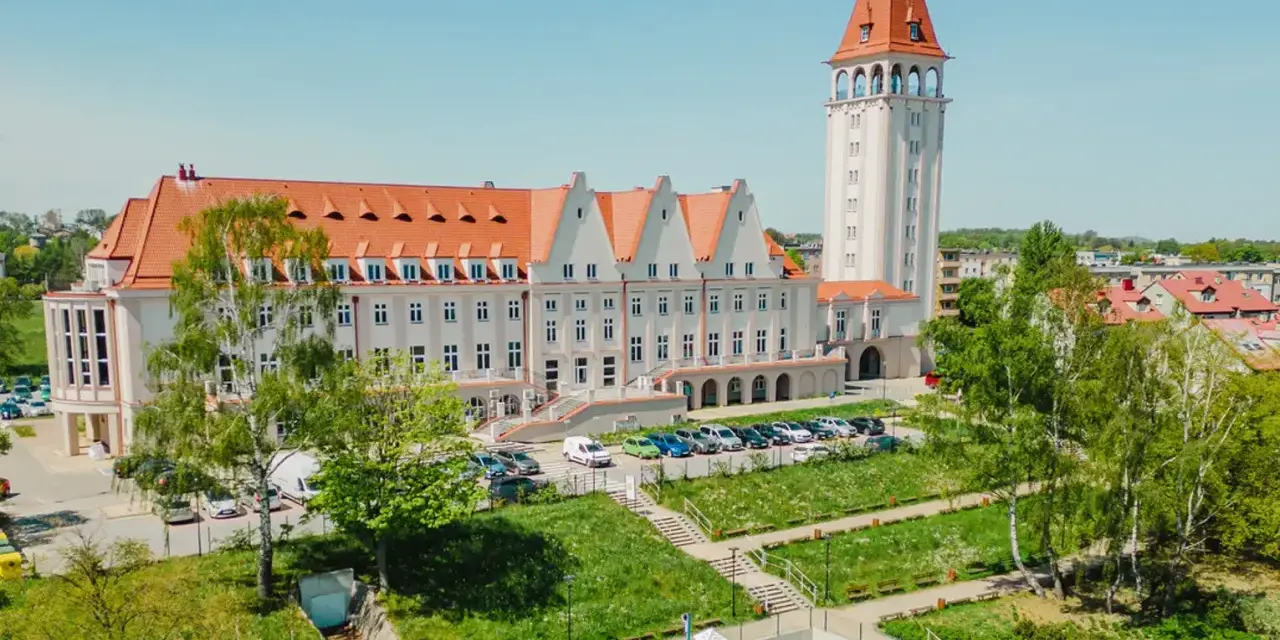 Władysławowo: okazały budynek z wieżą, dawny dom rybaka, otoczony zielenią i placem zabaw.