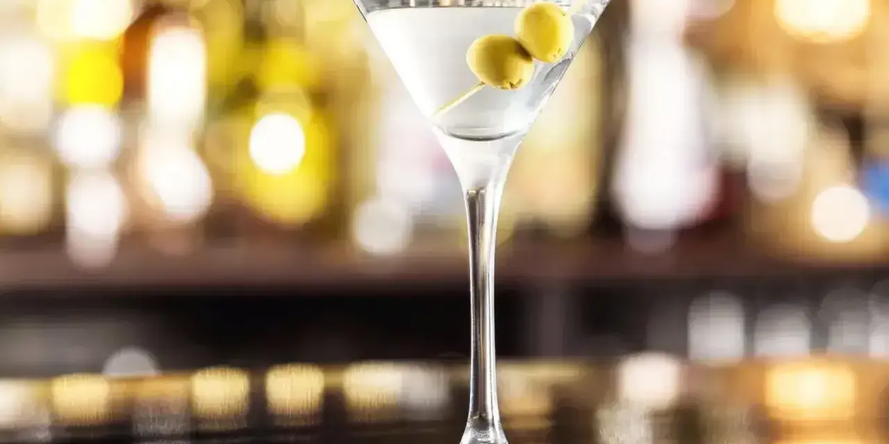 Klasyczny martini dry przepis: schłodzony gin, odrobina wermutu i dwie oliwki. Idealny drink na wieczór.