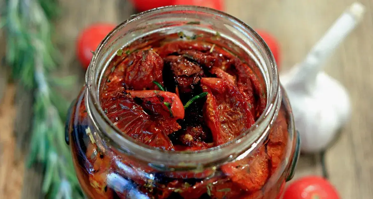 Pomodori secchi sott'olio, la ricetta della nonna. Un barattolo pieno di sole, profumato di rosmarino e aglio, pronto per insaporire ogni piatto.