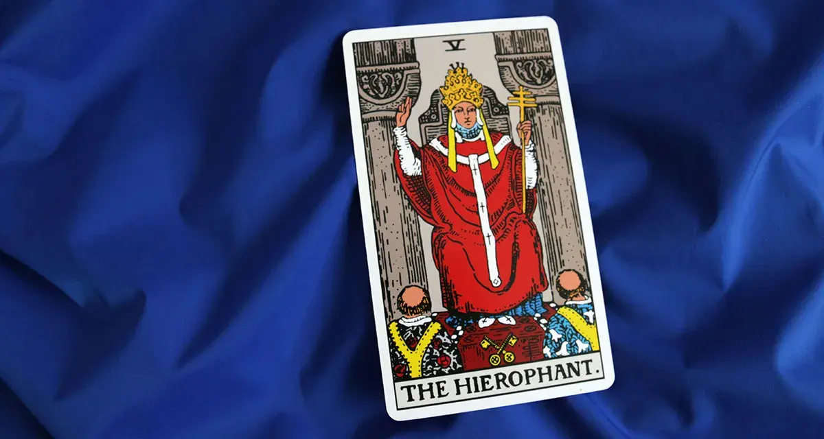 Karta Tarota "The Hierophant" na niebieskim tle. Symbolizuje tradycję, duchowość i przewodnictwo.