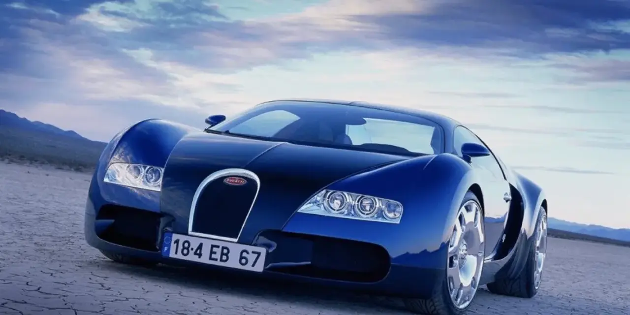 Niebieski Bugatti Veyron na pustynnym tle pod błękitnym niebem.