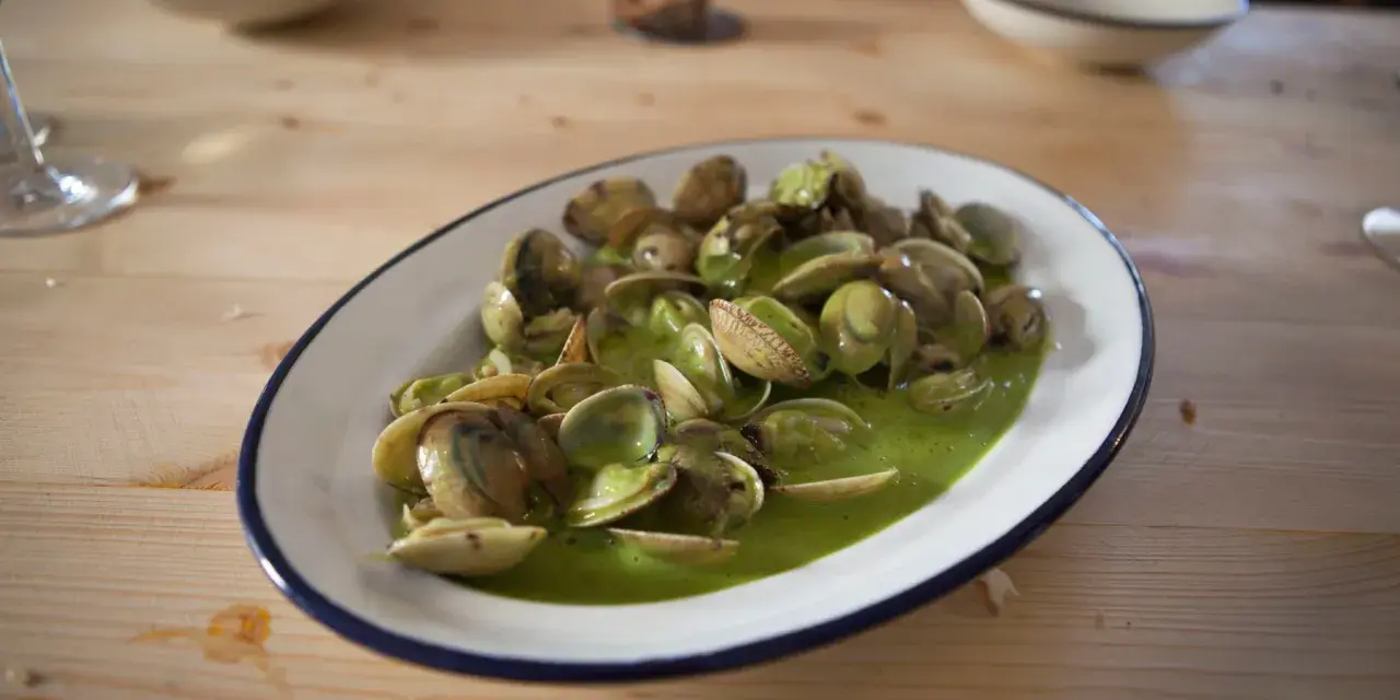 Deliciosas almejas en salsa verde, un plato que invita a saborear el mar.