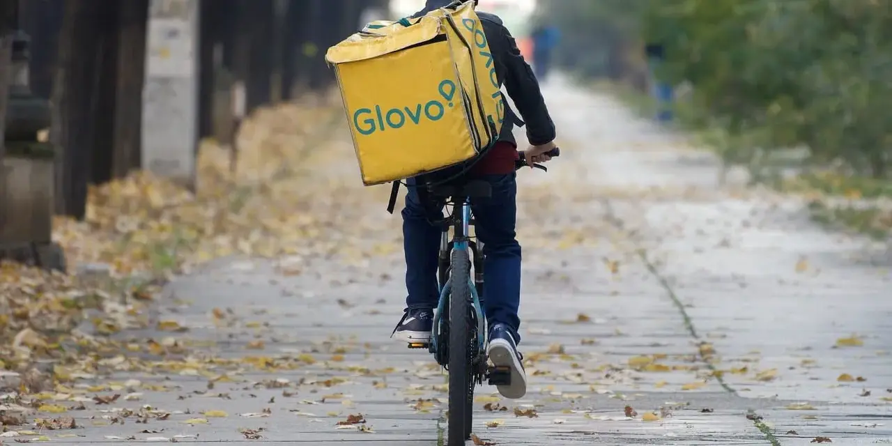 Kurier na rowerze z żółtą torbą Glovo jedzie ależsza. Chyba glovo nie działa, bo wygląda na zagubionego.