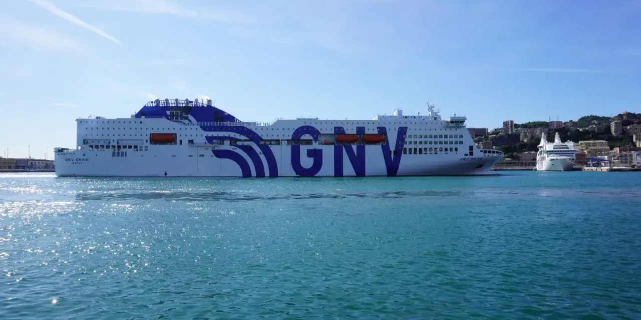 Ogromny prom GNV Orion czeka na pasażerów, by zabrać ich w podróż na Sycylię. W tle widać port i wzgórza.