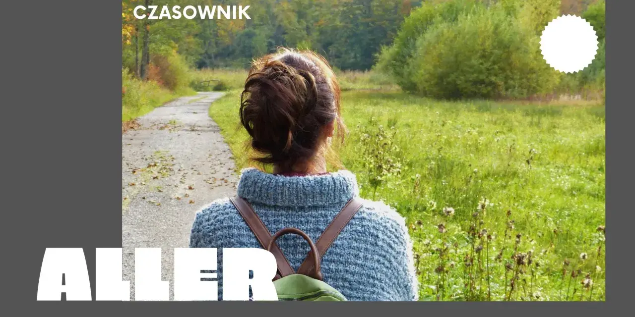 Osoby po francusku, spacerujące jesienną alejką wśród kolorowych drzew.