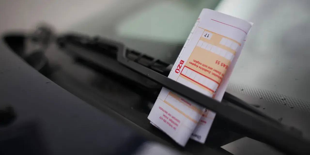 Ein Strafzettel unter dem Scheibenwischer. Parken ohne Parkschein kostet Geld und Ärger.