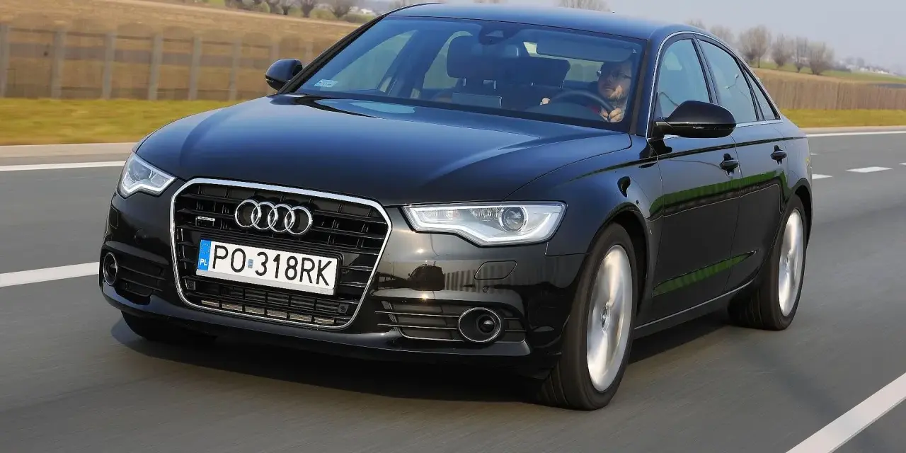 Czarne Audi A6 C7 3.0 TDI Biturbo w ruchu drogowym.