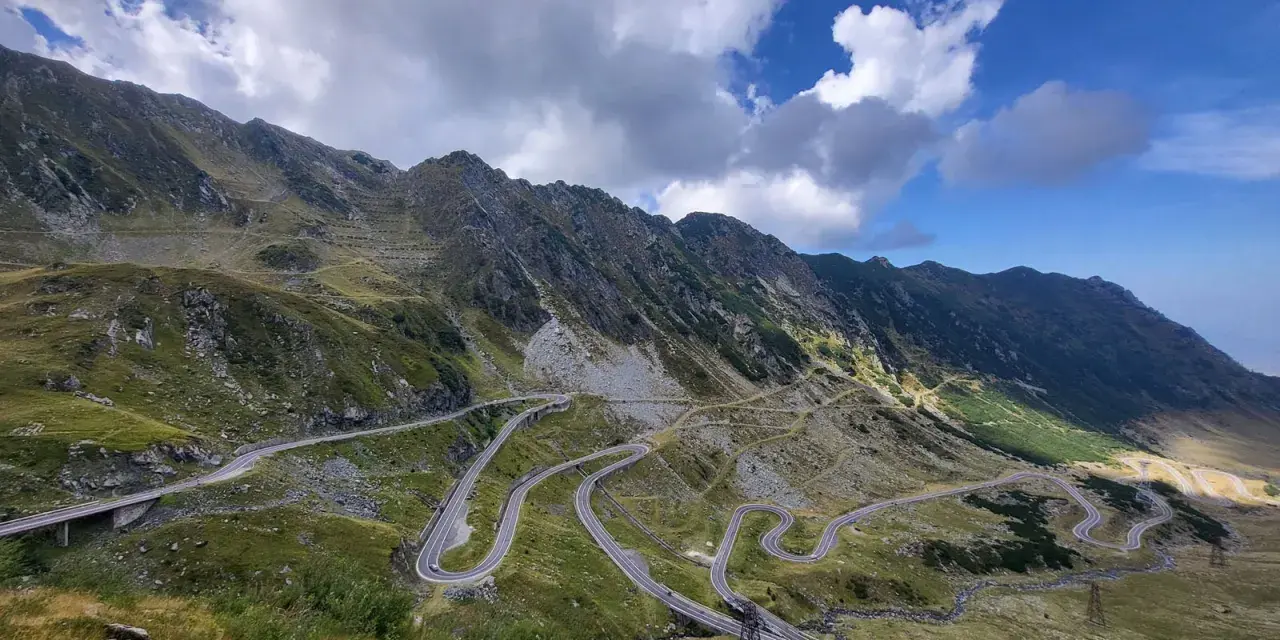 Wężykująca droga w górach Rumunii, idealna na wyprawę motocyklem. Widok zapiera dech w piersiach!