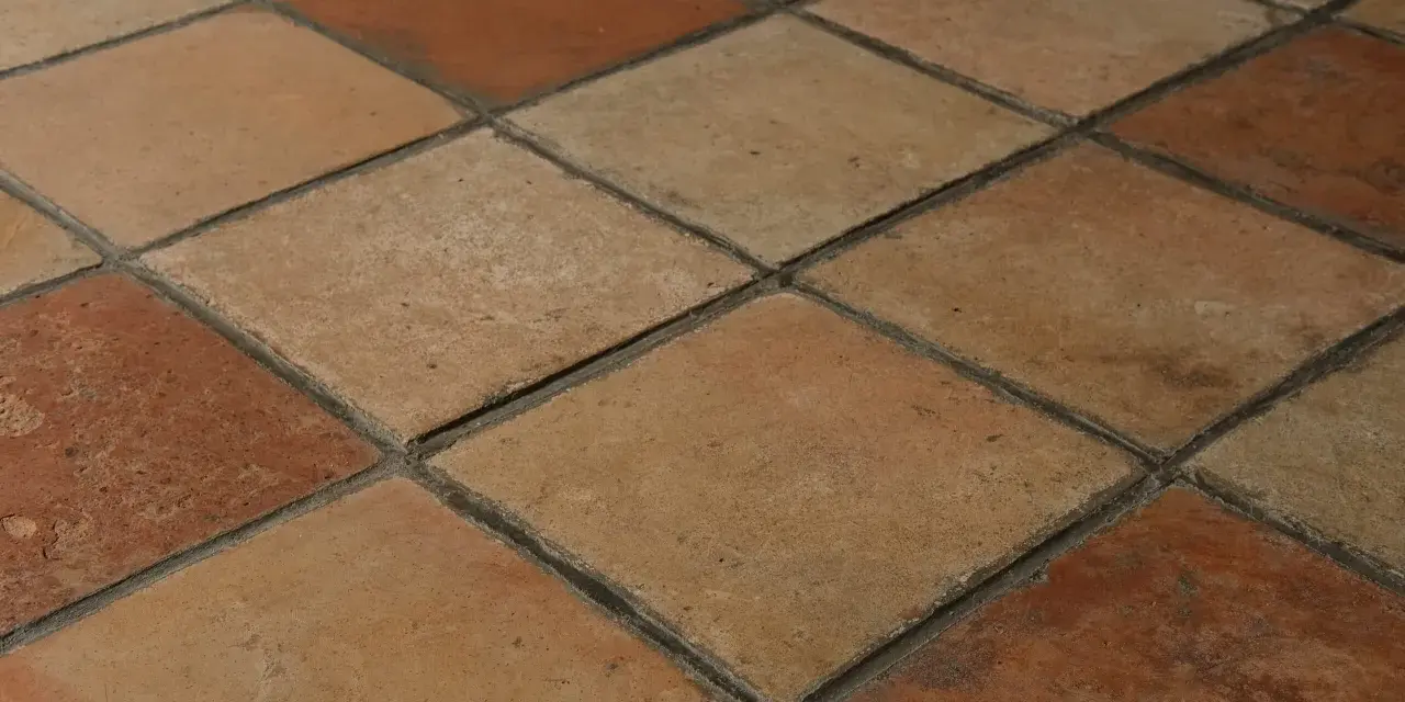Rödbruna och beige klinkerplattor i ett rutmönster. Tänk att måla klinkergolv för att ge det nytt liv!