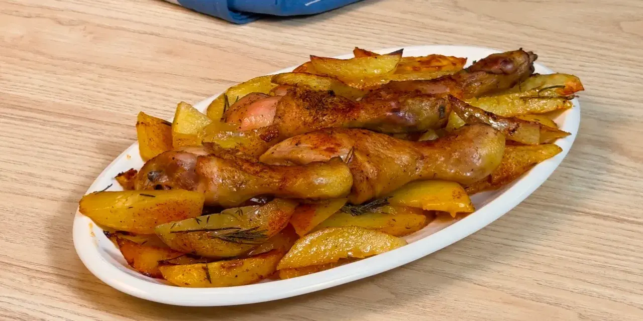 Pollo al forno con patate dorate e rosmarino, un piatto succulento pronto per essere gustato.