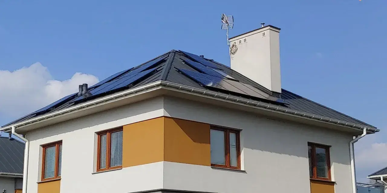 Nowy dom z panelami fotowoltaicznymi na dachu, korzystający z systemu net metering.