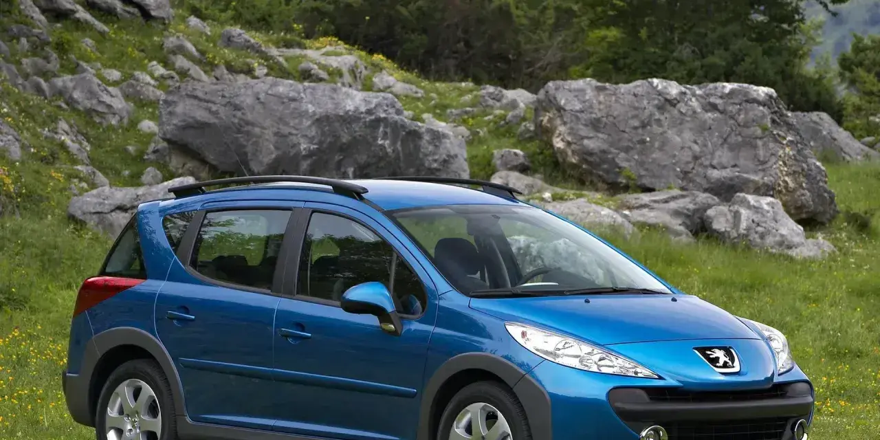 Niebieski Peugeot 207 SW na tle skalistego krajobrazu. Wiele osób szuka peugeot 207 opinie przed zakupem.