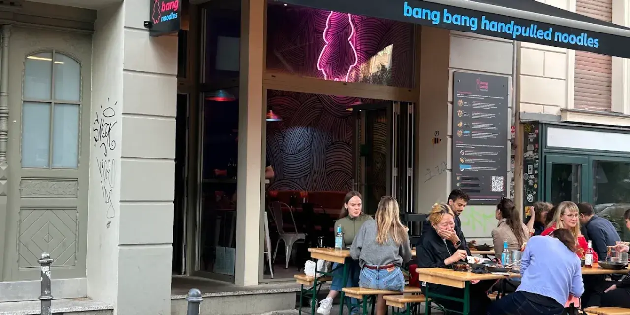 Menschen genießen das Essen vor dem Restaurant "bang bang noodles berlin".