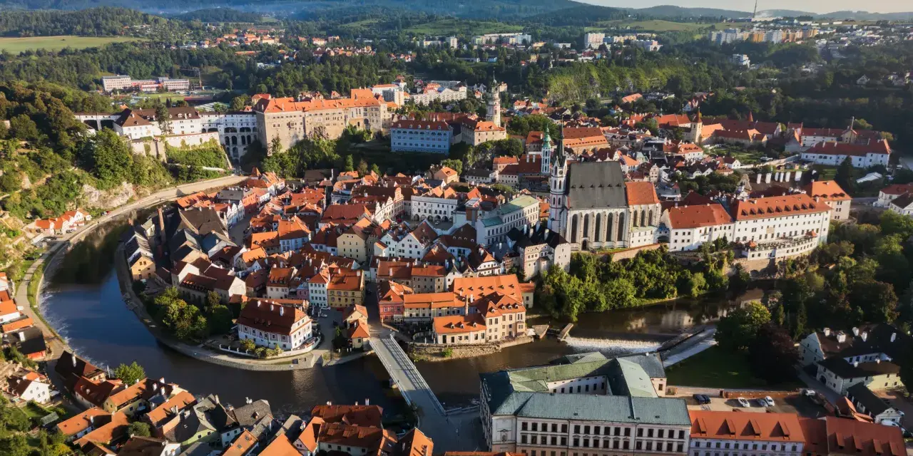 Widok na malowniczy Czeski Krumlov, gdzie rzeka Vltava otacza zabytkowe centrum z zamkiem i kościołem. To idealne miejsce, by odkrywać czeski krumlov atrakcje.